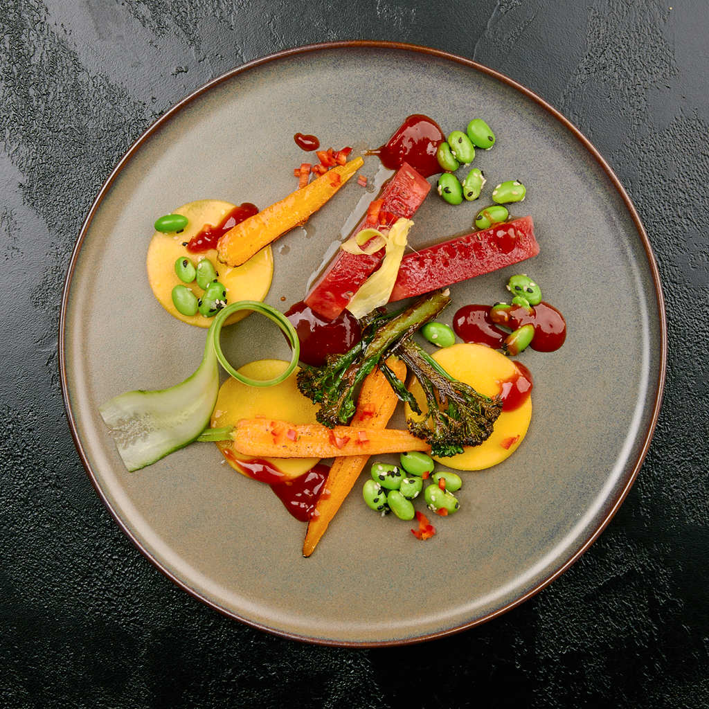 Frisch angerichtetes Mexiasian Confusion Tellergericht mit mexikanischen und asiatischen Zutaten, knackigem Gemüse und würziger Sauce auf einem Teller serviert.